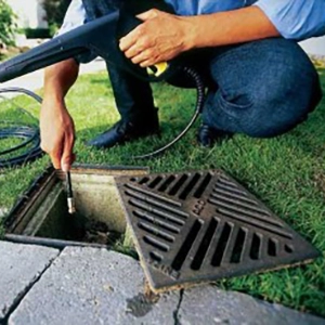 profissional desentupindo caixa de água pluvial