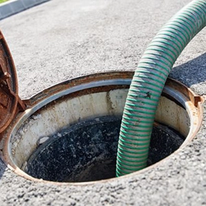 tubo do caminhão de desentupimento realizando esgotamento de fossa