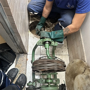 profissional realizando o desentupimento da caixa de gordura